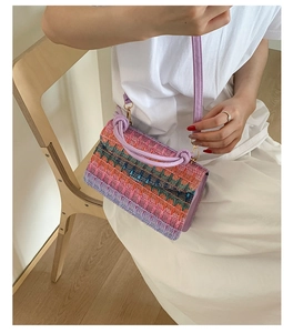 Detail view of colorful woven fiber patterns with golden buckles on a fashion rainbow bag