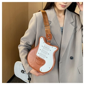 Détail du sac bandoulière en forme de guitare avec large sangle sur un mannequin