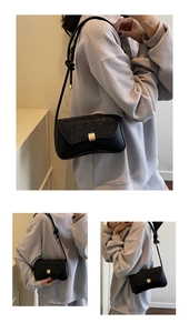 Detail of black baguette bag featuring sequined flap and golden square metal clasp buckle