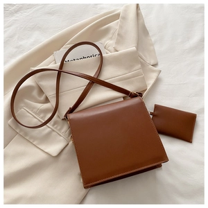 Sac bandoulière marron en similicuir avec rabat et mini pochette assortie sur tissu blanc