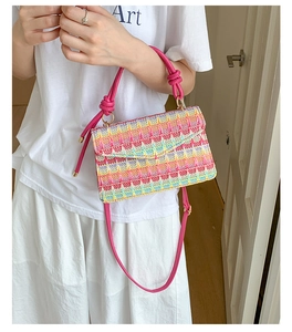Detail of multi-color woven crossbody bag with geometric pattern and pink knotted handle