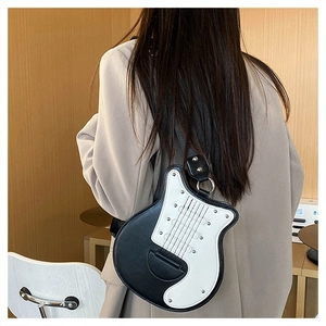 Détail du sac bandoulière en forme de guitare avec contraste noir et blanc chic
