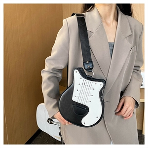 Détail du sac bandoulière en forme de guitare avec large sangle et accents rock