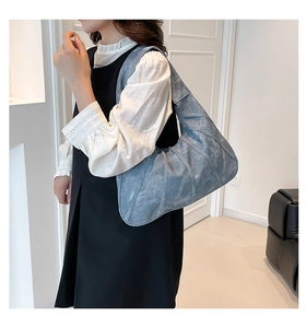 Haze blue tote bag featuring pleated faux leather texture shown on shoulder