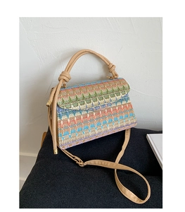 Detailed view of colorful woven geometric pattern on casual crossbody bag with leather handle
