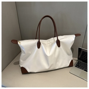 Bolso de viaje grande blanco con asas de cuero marrón y esquinas reforzadas para mujer