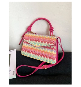 Macro view of multi-color woven texture and pink leather details on the crossbody bag