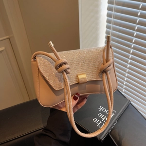 Elegant beige baguette bag with sparkling rhinestones and golden lock shown in hand