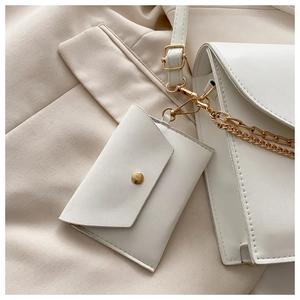 Détail du sac à bandoulière blanc crème avec chaîne dorée et mini pochette assortie