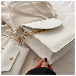 Détail du sac bandoulière blanc avec chaîne dorée et mini pochette amovible