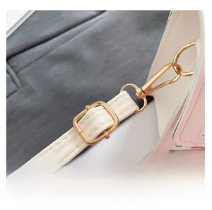 Detail of adjustable white leather strap with polished gold-tone lobster clasp