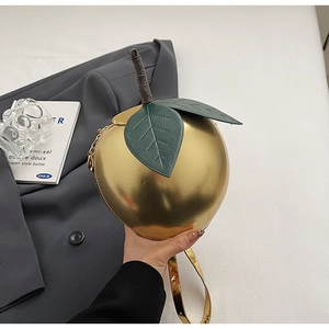 Vue détaillée du sac pomme doré créatif avec feuilles en cuir vert et chaîne dorée
