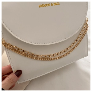Détail du sac en similicuir blanc avec double chaîne dorée et lettrage de mode chic