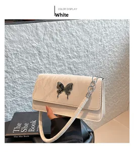 Detailed view of white quilted crossbody bag with marble pattern and silver butterfly buckle