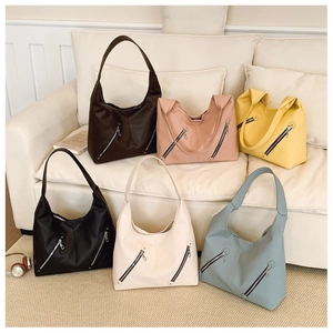 Detailed display of six stylish hobo bags in various colors on a soft fabric sofa