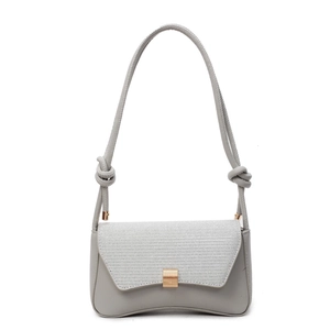 Light grey baguette shoulder bag with knotted strap and gold hardware on white background