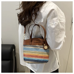 Detailed macro view of multi-color woven texture and premium leather strap on bucket bag