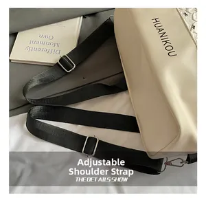 Detail of adjustable black nylon strap with silver metal buckle on cream leather bag