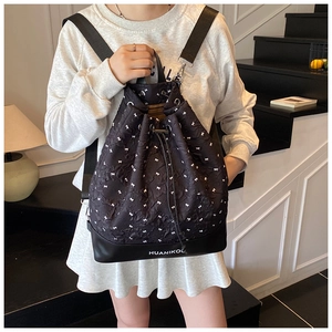 Detail of drawstring bucket backpack with bow pattern and silver metal hardware