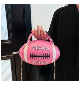 Detailed close-up of a pink rugby-shaped handbag featuring white letters and a gold chain