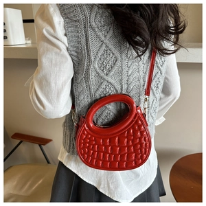 Detailed shot of a stylish red quilted PU leather circular handbag worn on a model's back