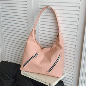 Large coral pink tote bag with lychee texture and decorative zippers on white shutters