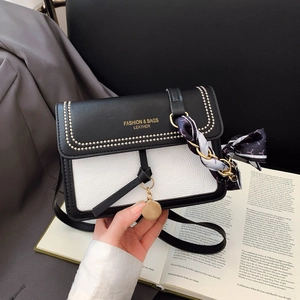 Detail of color-block leather crossbody bag with printed silk scarf and gold lettering
