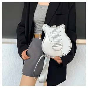 Vue détaillée du sac bandoulière argenté en forme de guitare avec bandoulière large