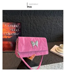 Detailed view of pink quilted handbag featuring a liquid metal silver butterfly emblem