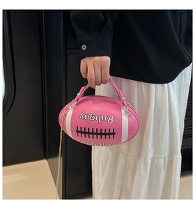 Detail of pink rugby-shaped handbag with golden chain and letter embossing