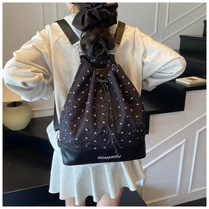 Detail of drawstring backpack featuring ribbon pattern and leather brand bottom