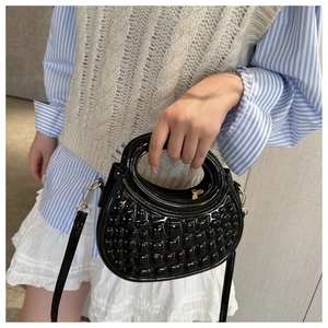 Detailed macro view of black glossy round PU handbag with embossed bubble texture finish