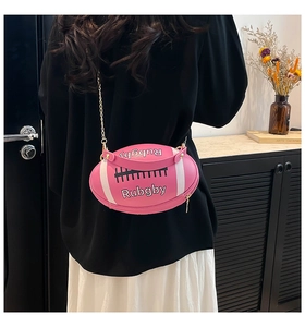 Detail of pink rugby-shaped handbag with white lettering and gold chain strap