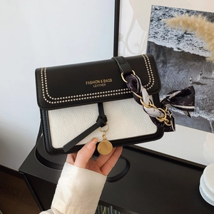 Chic black and white contrast leather crossbody bag with silk scarf and gold chain detail