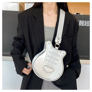 Détail du sac bandoulière argenté en forme de guitare avec rivets et sangle large