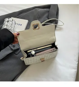 Internal capacity of white quilted shoulder bag showing phone and lipstick storage space