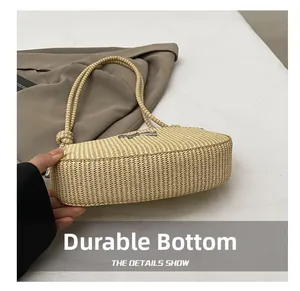 Close-up of durable woven bottom and knot detail on a minimalist straw shoulder bag