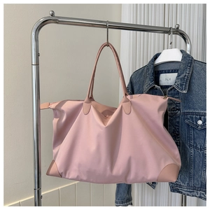 Gran bolso de viaje de nailon rosa colgado en un perchero para viajes cortos y traslados
