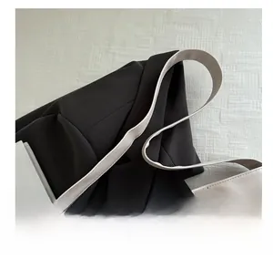 Detail of beige tote bag featuring metallic rivets and premium leather handle texture