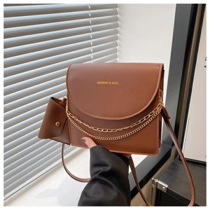 Détails d'un sac porté épaule vintage marron avec chaînes dorées et mini porte-monnaie