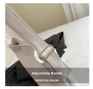 Close-up of adjustable silver metal buckle on a cream leather shoulder bag strap