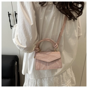 Detail of pink pleated mini handbag featuring knotted handle and gold metal ring link