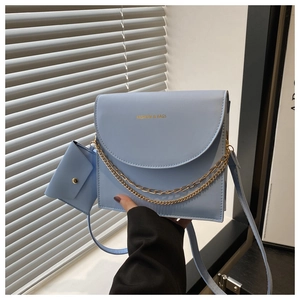 Détail du sac bandoulière bleu clair avec texte doré et mini pochette amovible