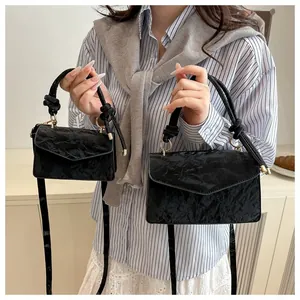 Detailed comparison of large and small black textured leather handbags with knot handle