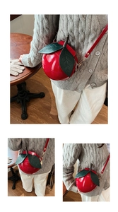 Gros plan d'un sac bandoulière créatif en forme de cerise avec feuille et bandoulière