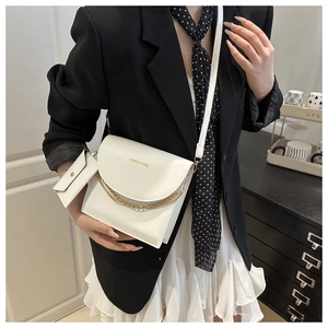 Détail d'un sac bandoulière blanc en similicuir avec chaîne dorée et pochette assortie