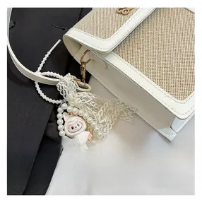 Detail of a contrast stitching crossbody bag with a cute rabbit pearl pendant charm