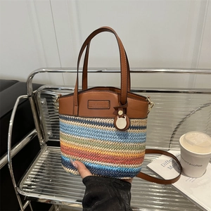 Rainbow woven straw bucket bag with brown leather handles and adjustable shoulder strap