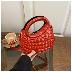 Close-up of a stylish red PU leather handbag with unique embossed grid texture detail