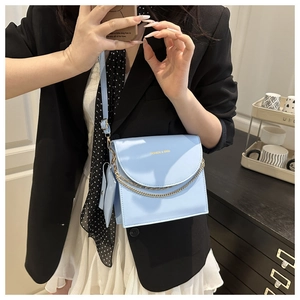 Détail d'un sac bandoulière en cuir PU bleu clair avec chaîne dorée et logo Fashion
